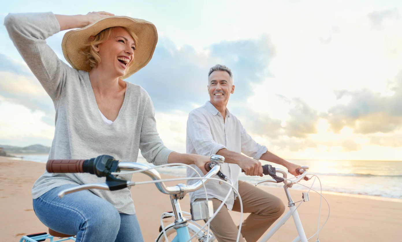 Couple riding bikes on beach