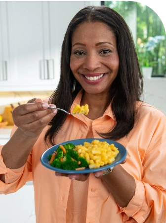 woman eating veggies and mac and cheese